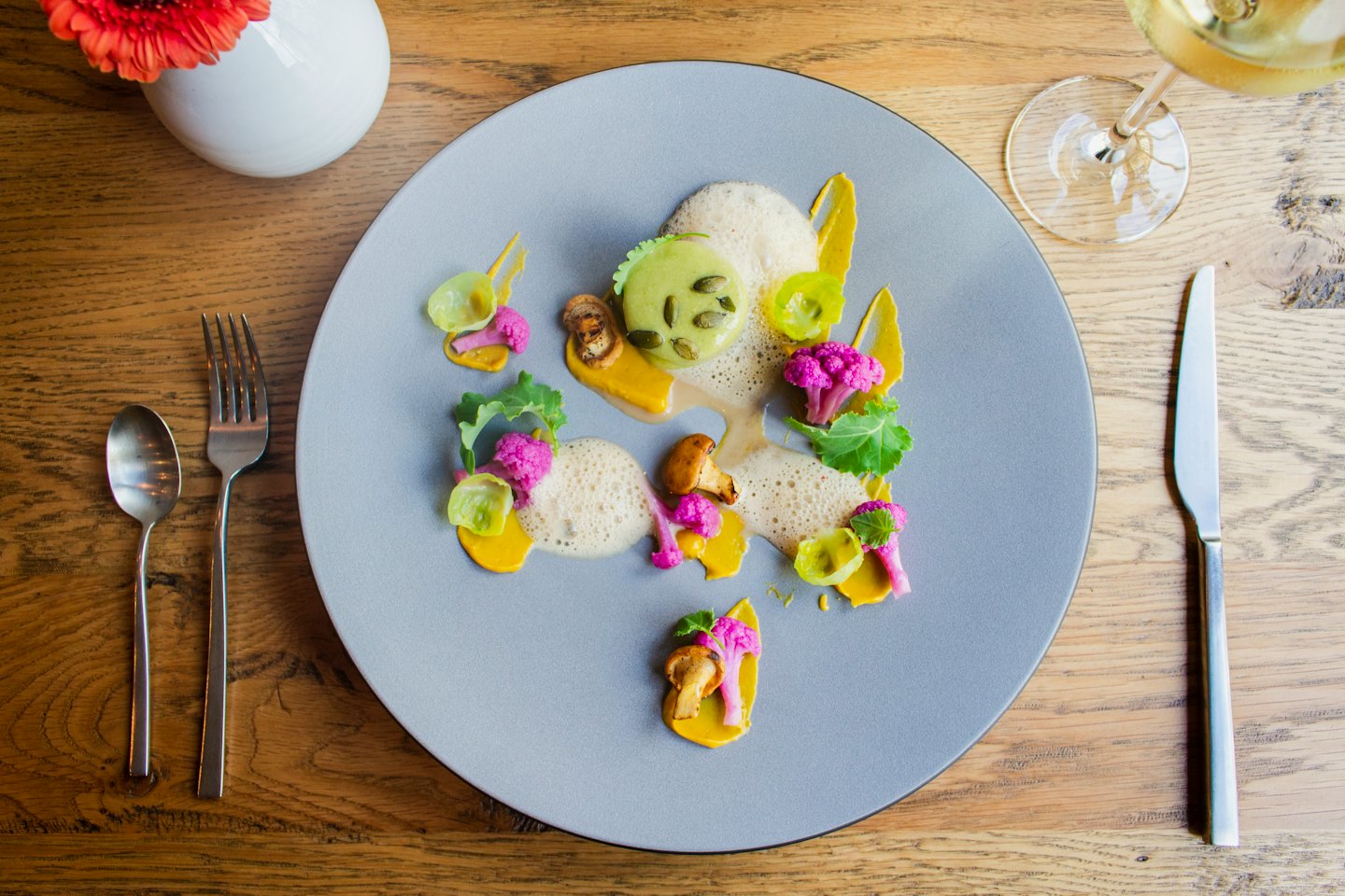 Gourmet vegetable dish artfully arranged on a plate with cutlery.