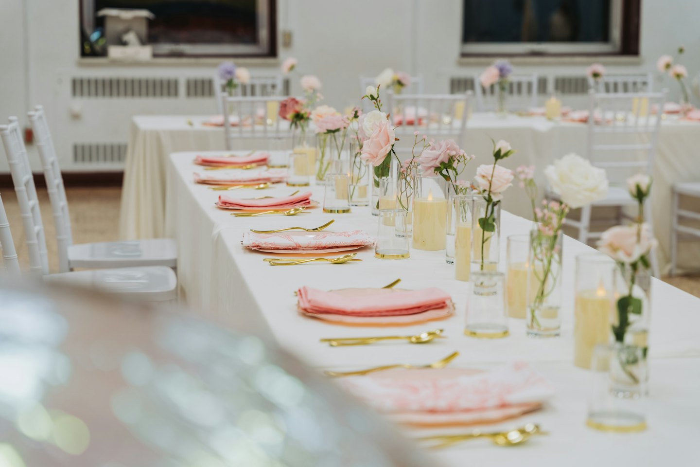 Elegant table set with floral arrangements and candles for an event.